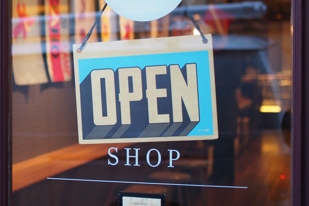 "Open" sign hanging at shop's entrance door